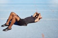 Tired track athlete lying down and feeling exhausted. Active, fit, competitive runner suffering from burnout, heatstroke Royalty Free Stock Photo