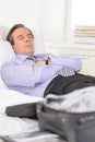 Tired of traveling. Tired mature businessman sleeping on the sofa at home Royalty Free Stock Photo