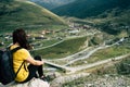 Tired traveling woman resting on hill. Exhausted male tourist sitting on stone after active trekking in mountains