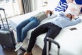 Tired traveling young couple laying with hands behind the head on bed in a hotel room