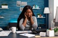 Tired unhappy frustration african student having headache pain sitting at desk Royalty Free Stock Photo