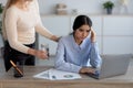 Tired unhappy millennial indian woman suffer from headache and stress at workplace in office interior Royalty Free Stock Photo