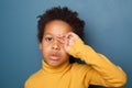 Tired unhappy small black child boy crying up on blue background