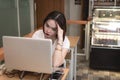 A tired and unmotivated female freelancer or businesswoman. Stressed and listless asian woman at a coworking space or cafe.