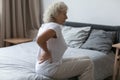 Tired upset elderly woman feeling strong lower backpain