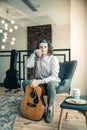 Tired upset guy with colorful bandana leaning on his guitar Royalty Free Stock Photo