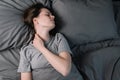 Tired upset woman with closed eyes massage tense neck muscles lying in bed, stress relief, exhausted girl suffering from pain Royalty Free Stock Photo