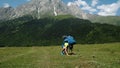 Tired and weak tourist with a heavy backpack gets up from the ground on a hike against the backdrop of a beautiful