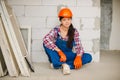 Tired worker sit on concrete floor after hard work. women`s work in men`s professions and equality Royalty Free Stock Photo