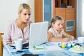 Tired woman with daughter working online