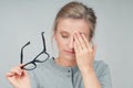 Tired woman with eyeglasses, covering eye with hands Royalty Free Stock Photo