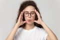 Tired woman in eyewear massaging temples, trying to reduce stress. Royalty Free Stock Photo