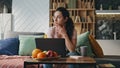 Tired woman freelancer working remotely sitting home couch with coffee cup. Royalty Free Stock Photo