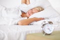 Tired, woman and frustrated with alarm in bed with stress and fatigue in morning at home. Wake up, time and girl to Royalty Free Stock Photo