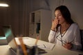 Tired woman with papers yawning at night office Royalty Free Stock Photo