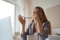 Tired woman sitting at desk with laptop, holding head, resting on hand, sleeping at workplace, bored young female Royalty Free Stock Photo