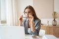 Tired woman sitting at desk with laptop, holding head, resting on hand, sleeping at workplace, bored young female Royalty Free Stock Photo