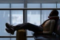 Tired woman sleep in airport on chair with legs on suitcase waiting for transit flight departure Royalty Free Stock Photo