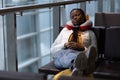 Tired woman sleep in airport on chair with legs on suitcase waiting for transit flight departure Royalty Free Stock Photo