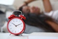 Tired woman sleeping couch, set wake up time alarm Royalty Free Stock Photo