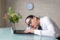 Tired woman sleeping on desk at laptop Royalty Free Stock Photo