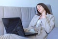 Tired woman sleeping working on laptop sitting on couch at home, distant work. Royalty Free Stock Photo