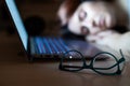 Tired woman sleeping at workplace near laptop. girl dozed off for remote work. Overworked student fell asleep on the Royalty Free Stock Photo
