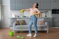 Tired woman taking a break from mopping the floor Royalty Free Stock Photo