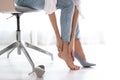 Tired woman taking off shoes at office Royalty Free Stock Photo