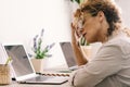 Tired woman touching neck and glasses in front of a. laptop in home office workplace. Small online business computer technology Royalty Free Stock Photo