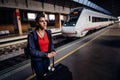 Tired woman traveler with bags and suitcase waiting on the peron of a train station.Traveling with train/metro.Last minute