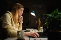 Woman works at home office at night, using laptop Royalty Free Stock Photo