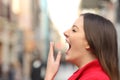 Tired woman yawning in the street