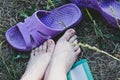 Tired women`s feet smeared with earth lie on the grass and there are slates next to them Royalty Free Stock Photo