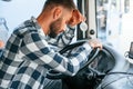 Tired of work. Sitting in the cabin. Young truck driver is with his vehicle at daytime Royalty Free Stock Photo