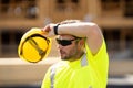 Tired worker. Construction worker with hardhat helmet on construction site. Construction engineer worker in builder Royalty Free Stock Photo