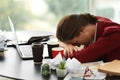 Tired worker with a lot of work sitting at table in office Royalty Free Stock Photo