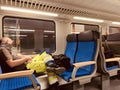 A tired worker sleeping in a chair in a modern train in Berlin