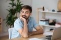 Tired worker wasting time at workplace distracted from boring job
