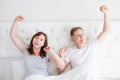 Tired yawn middle age couple in bed. Blank template t shirt. Family life and healthy relationships. Health care and morning