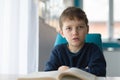 Tired 8 years old boy doing his homework at the table Royalty Free Stock Photo