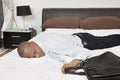 Tired young African American businessman sleeping in bed Royalty Free Stock Photo