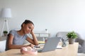 Tired young african american schoolgirl in headphones study at home with laptop, take break Royalty Free Stock Photo