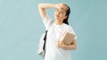 Tired young asian female student in casual clothes backpack hold books put hand on forehead have headache isolated on blue Royalty Free Stock Photo