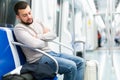 Tired young bearded man sleeping in subway car Royalty Free Stock Photo