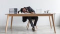 Tired young black businessman sleeping on desk in front of laptop, overworking, feeling exhausted at office, full length Royalty Free Stock Photo