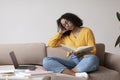 Tired young black woman sleeping with book near laptop computer at home, copy space Royalty Free Stock Photo