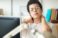 Tired young business woman with neck pain while working with computer in the office Royalty Free Stock Photo