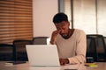 Tired Young Businessman Working Late Sitting At Desk With Laptop In Modern Open Plan Office Royalty Free Stock Photo