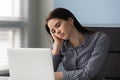 Tired young businesswoman thinking about work problem at laptop. Royalty Free Stock Photo